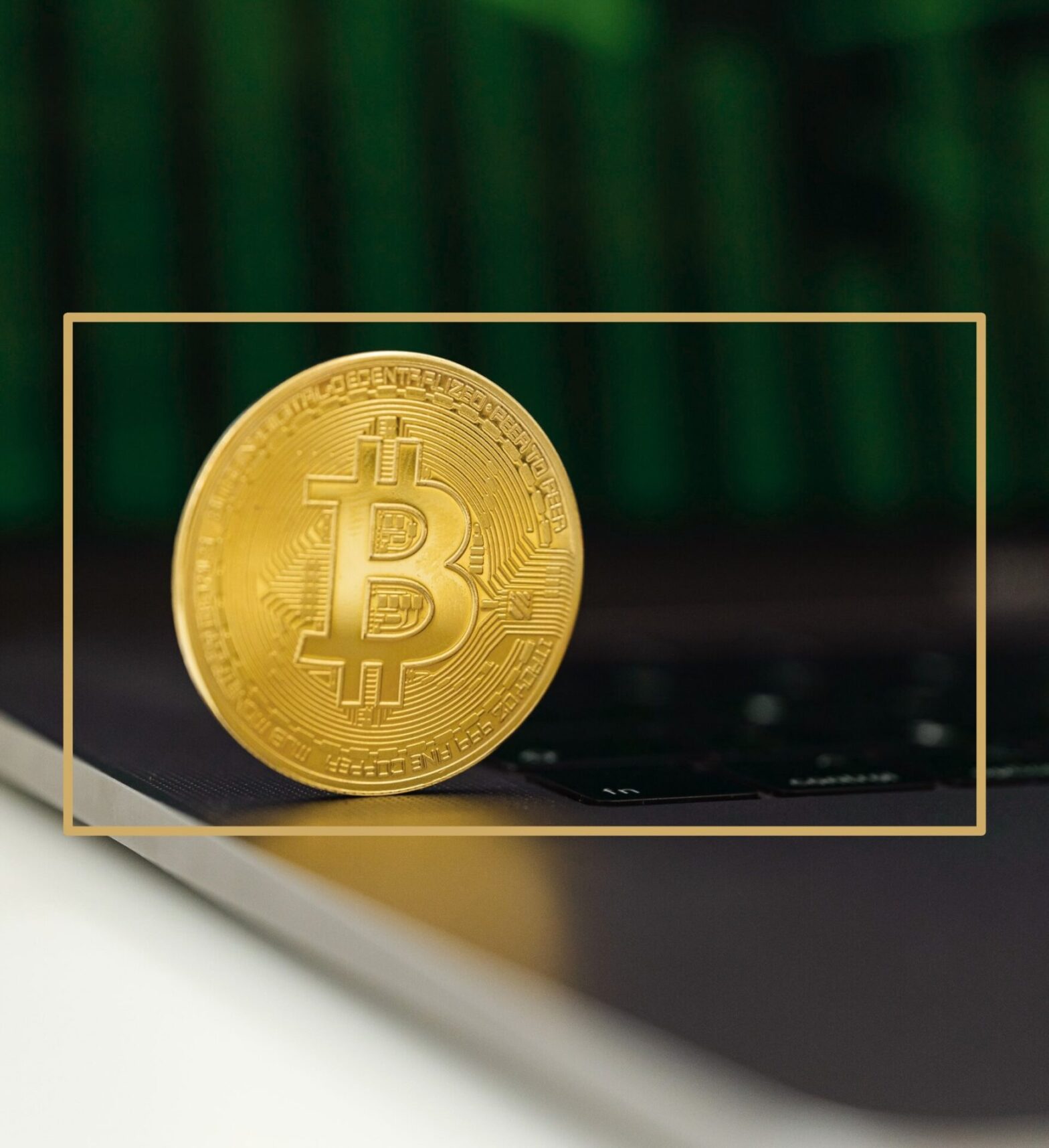 Goldene Bitcoin-Münze steht aufrecht auf einer Laptop-Tastatur vor grünem Hintergrund
